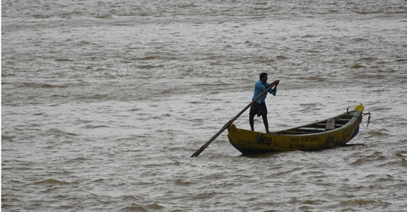 A person rowing a traditional yellow boat on water